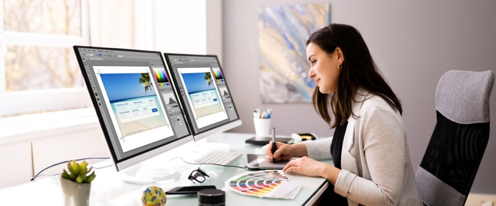 Female web designer with dual monitors at desk