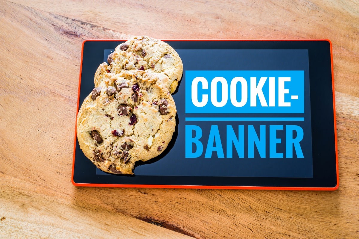 A tablet displaying a cookie consent banner on a wooden table.