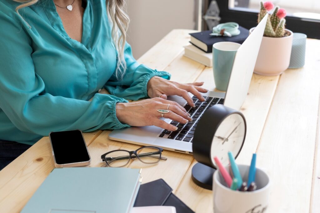 A woman working on her laptop at a desk, focused on copywriting and content writing.