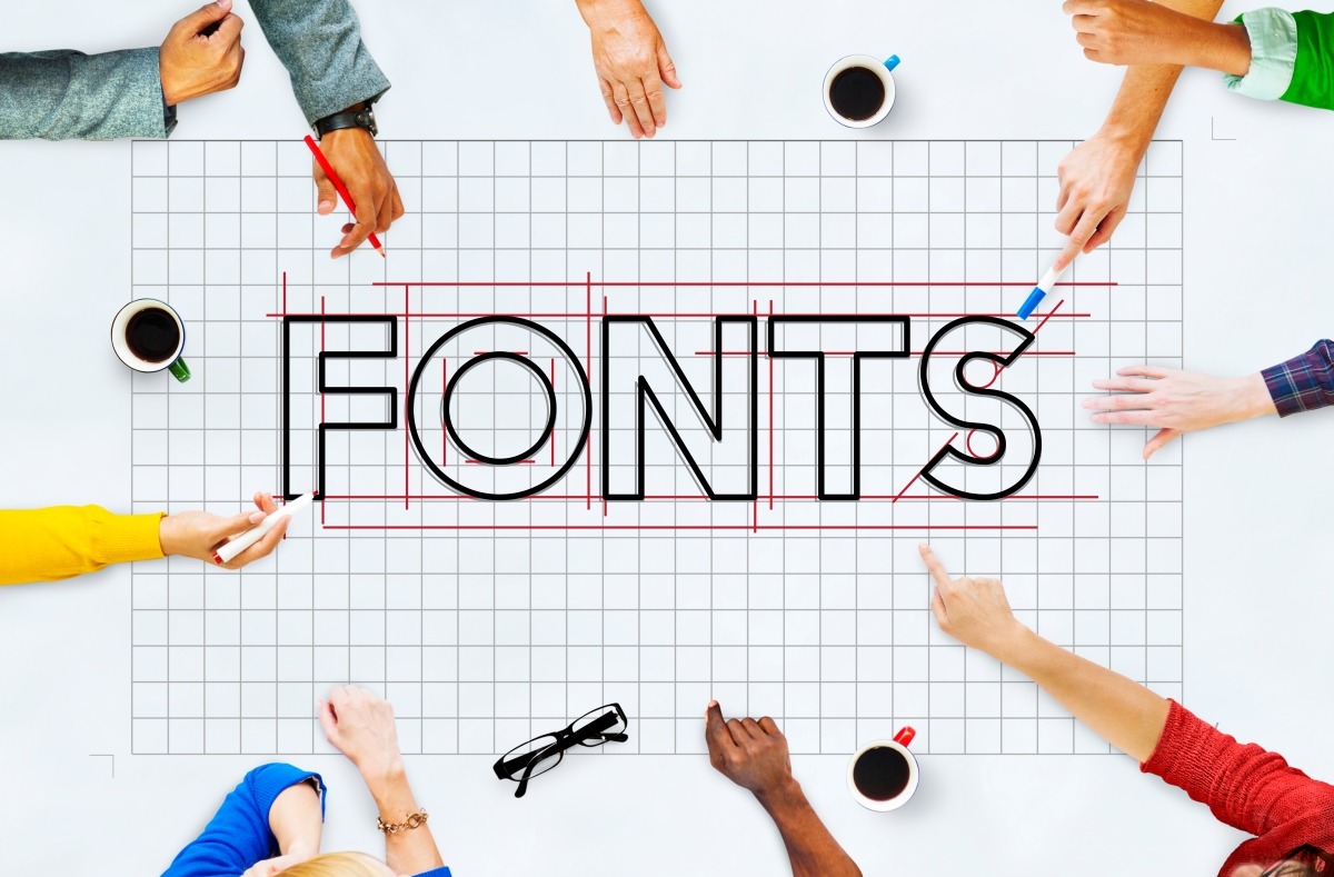 A group of people around a table discussing font pairings for websites.